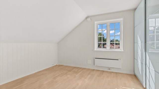 Soverom i andre etasje innredet med romslig skyvedørsgarderobe.