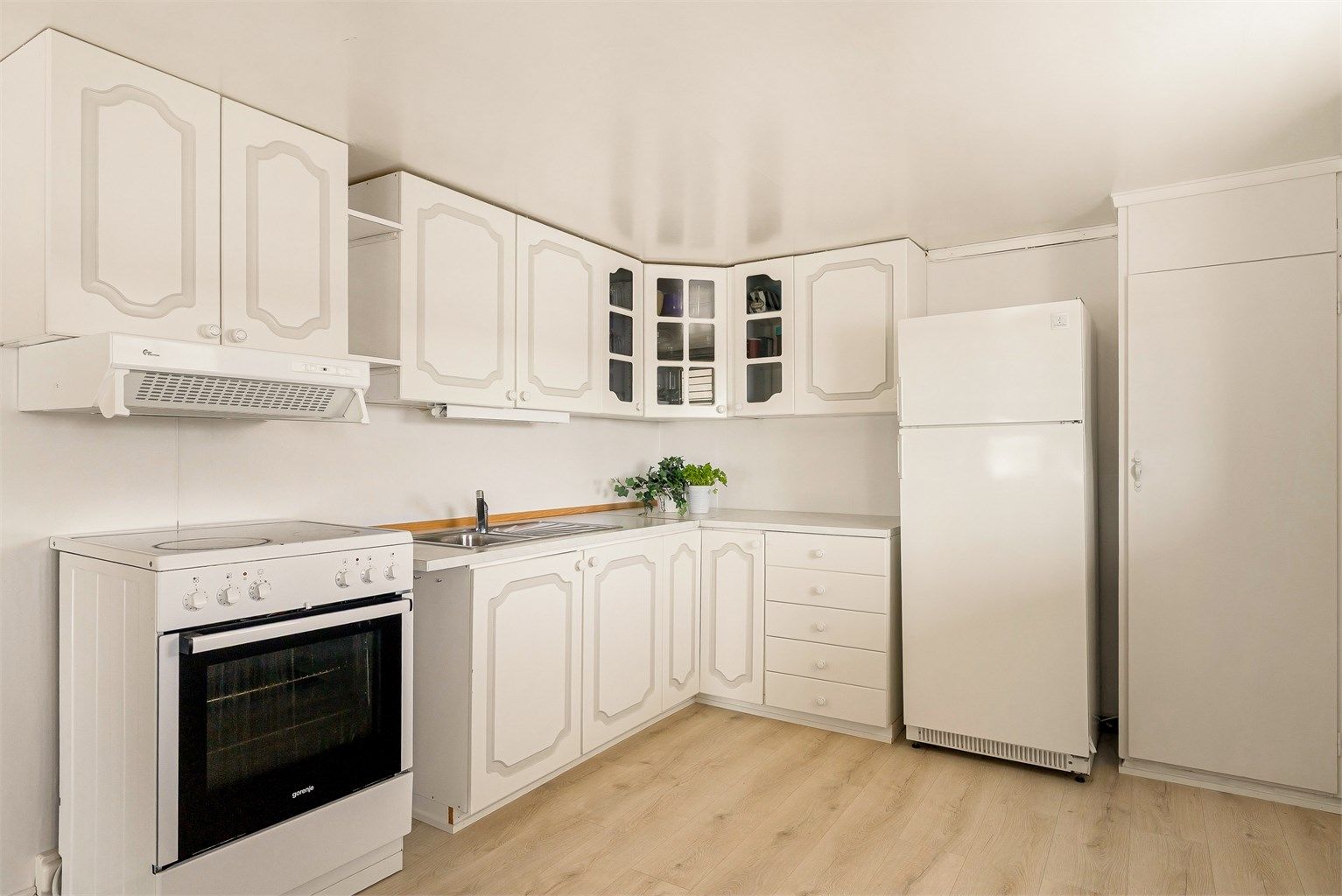 Kjøkken ligger i delvis åpen løsning mot stuen. Innredningen har profilerte fronter og laminert benkeplate. Komfyr og kjøleskap medfølger.