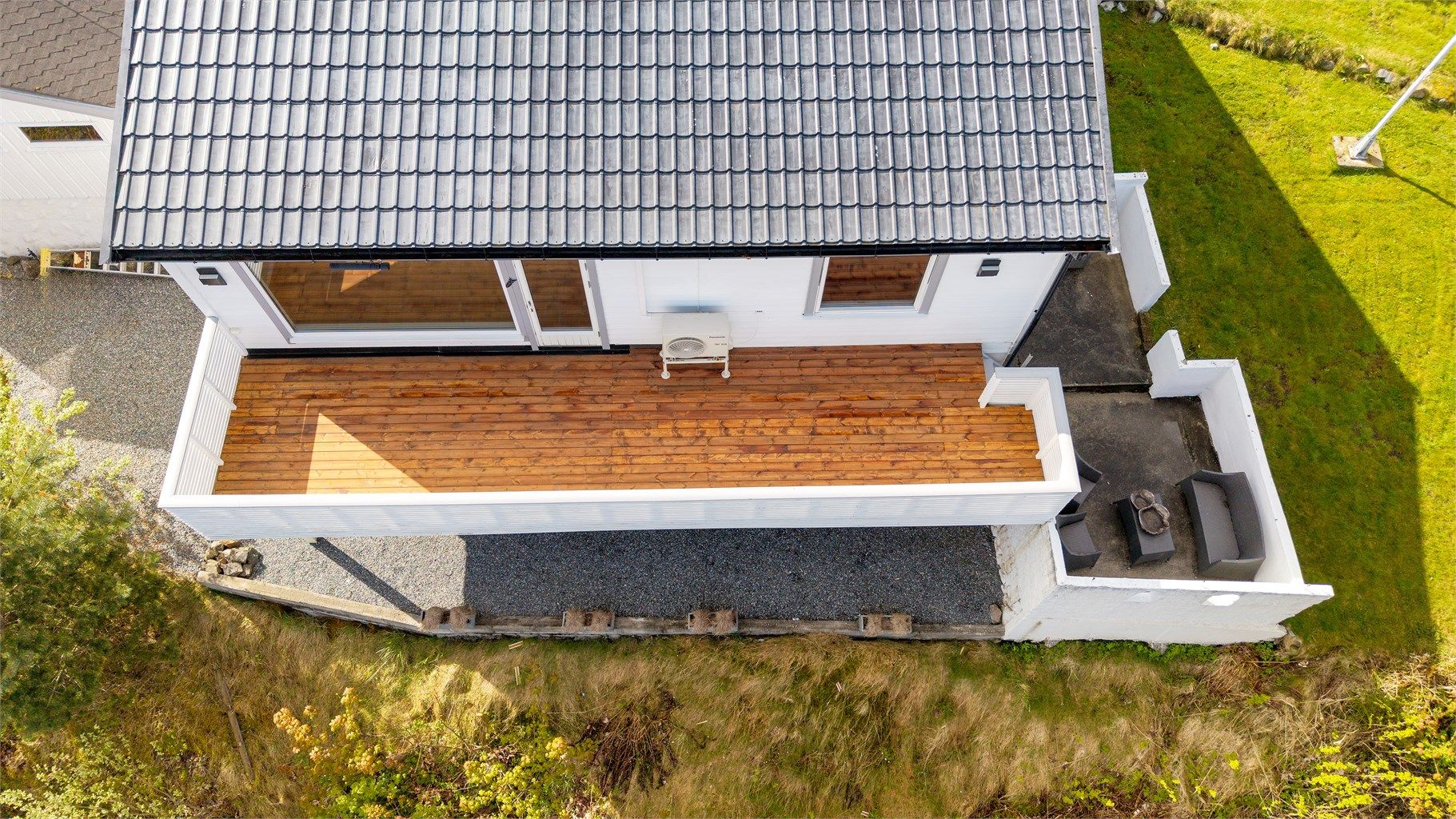 Terrassen i trekonstruksjon har rekkverk av tre. Nytt dekke i 2026