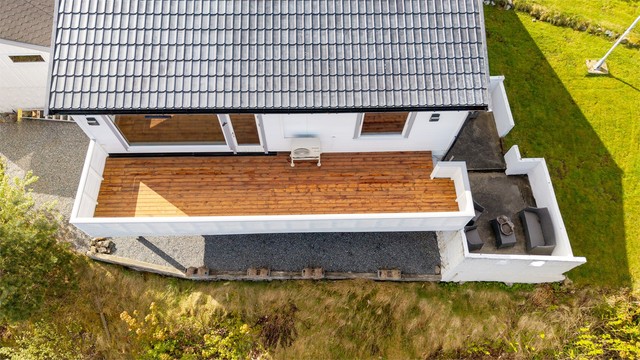 Terrassen i trekonstruksjon har rekkverk av tre. Nytt dekke i 2026