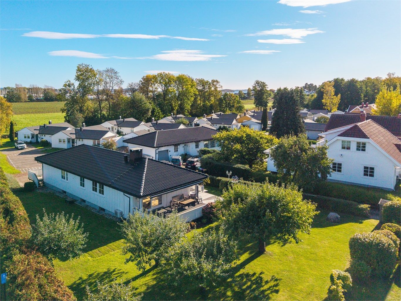 Tomten fremstår som lettstelt og innbydende, med gode parkeringsforhold og en skjermet atmosfære.