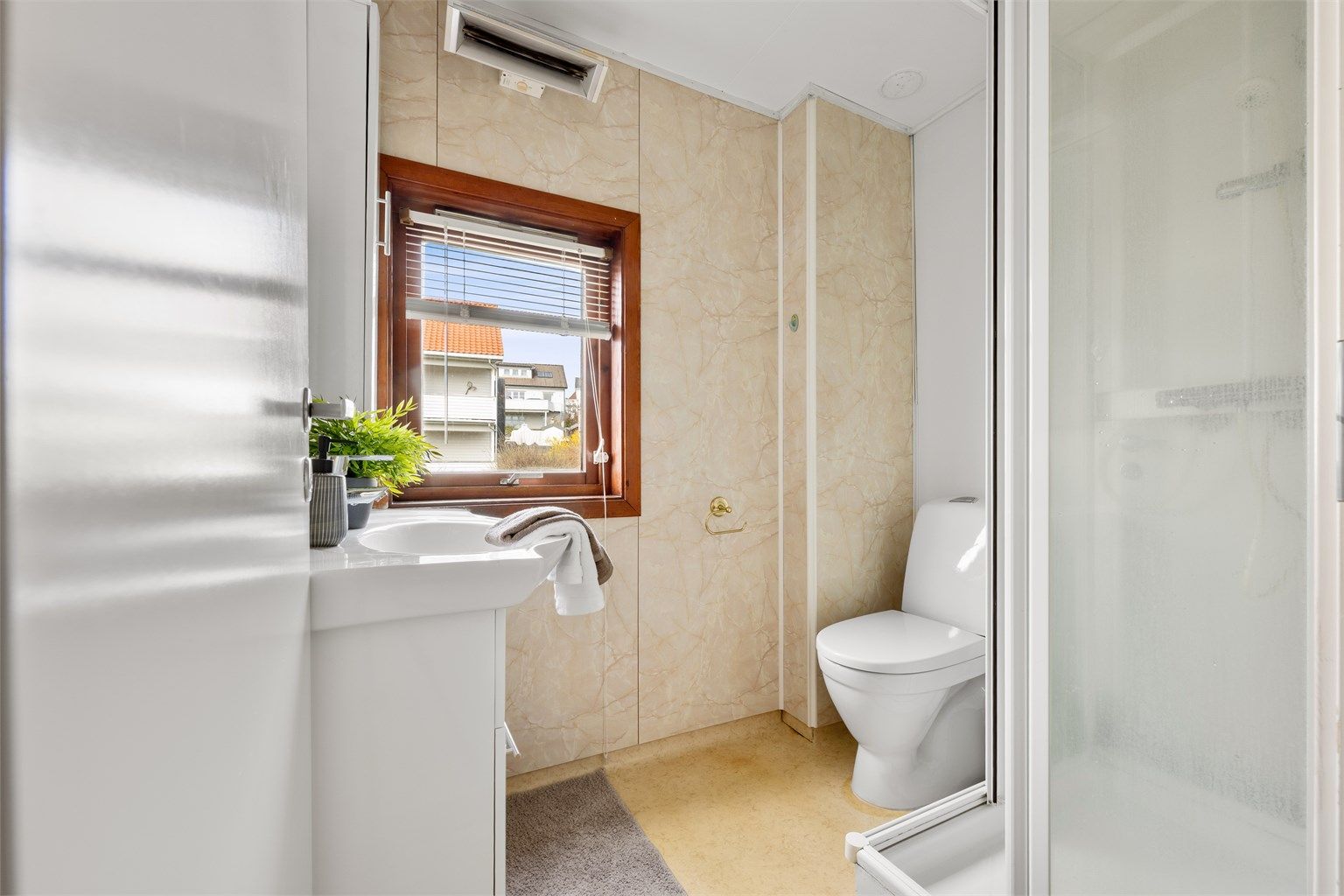 Bad er av eldre stander og har belegg på gulv og våtromsplater på vegg. Det er servant, toalett og dusjkabinett. 