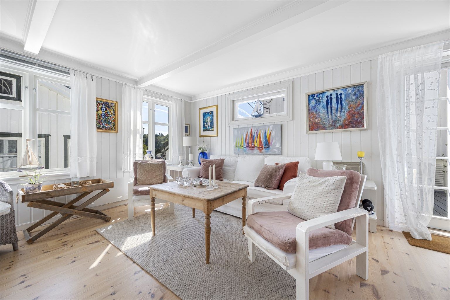 Stuen har utgang til treterrassen, noe som utvider oppholdsarealet i sesong.