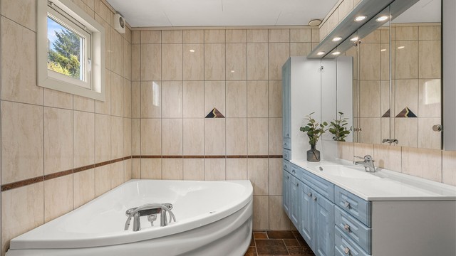 Pent flislagt bad med gulvvarme og downlights i himling.