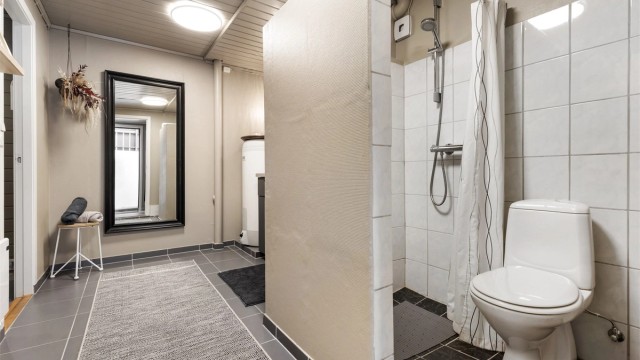 Badet har gulvstående toalett og dusjnisje.
