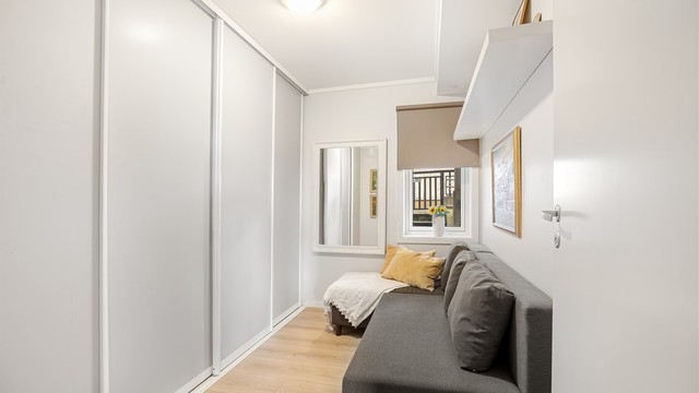 Soverom med skyvedørsgarderobe som gir rikelig med lagringsplass.