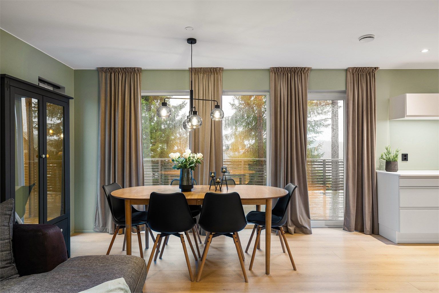 Spiseplassen nyter et behagelig kveldsskjær og en nær forbindelse til terrassen, som løfter romfølelsen mot tretopphorisonten.