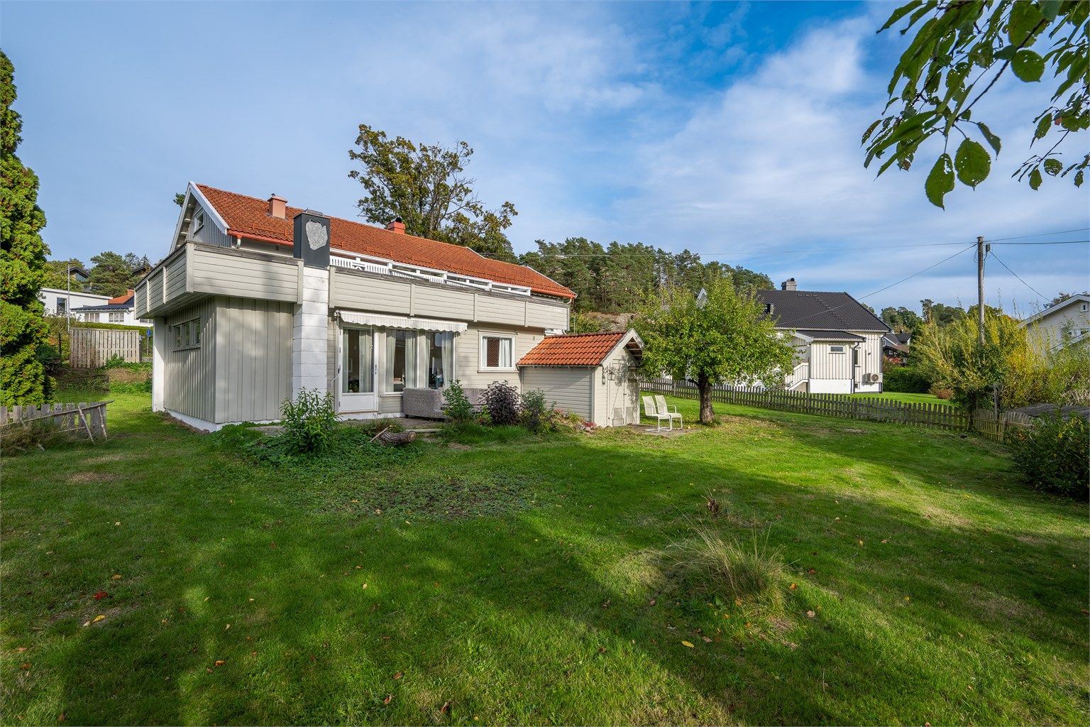 Eiendommen har en stor hagetomt med romslige gressarealer og skjermede uteplasser.