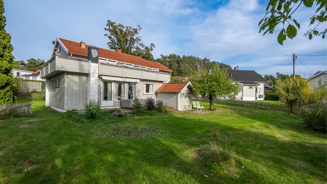Eiendommen har en stor hagetomt med romslige gressarealer og skjermede uteplasser.