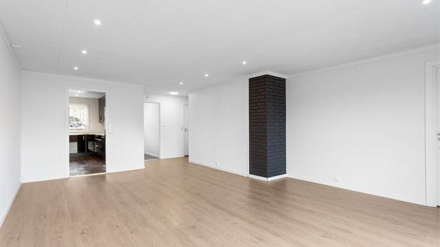 Stuen har god plass til både sofagruppe og spisebord, med videre adkomst til kjøkkenet.