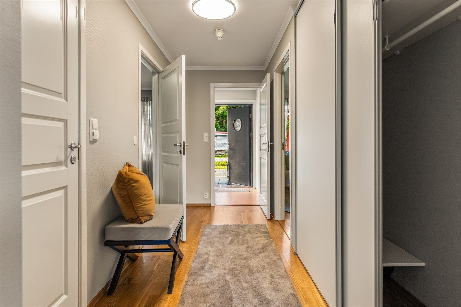 Romslig entré og gang med skyvedørsgarderobe for god oppbevaring.