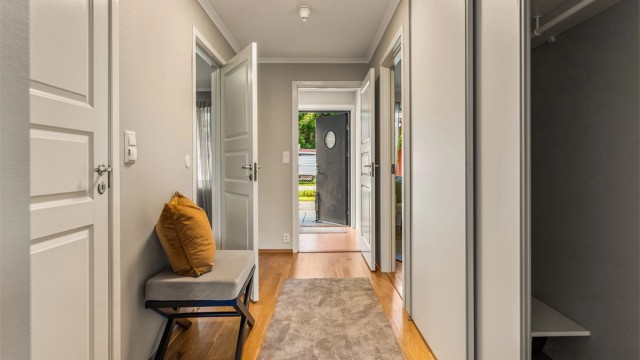 Romslig entré og gang med skyvedørsgarderobe for god oppbevaring.