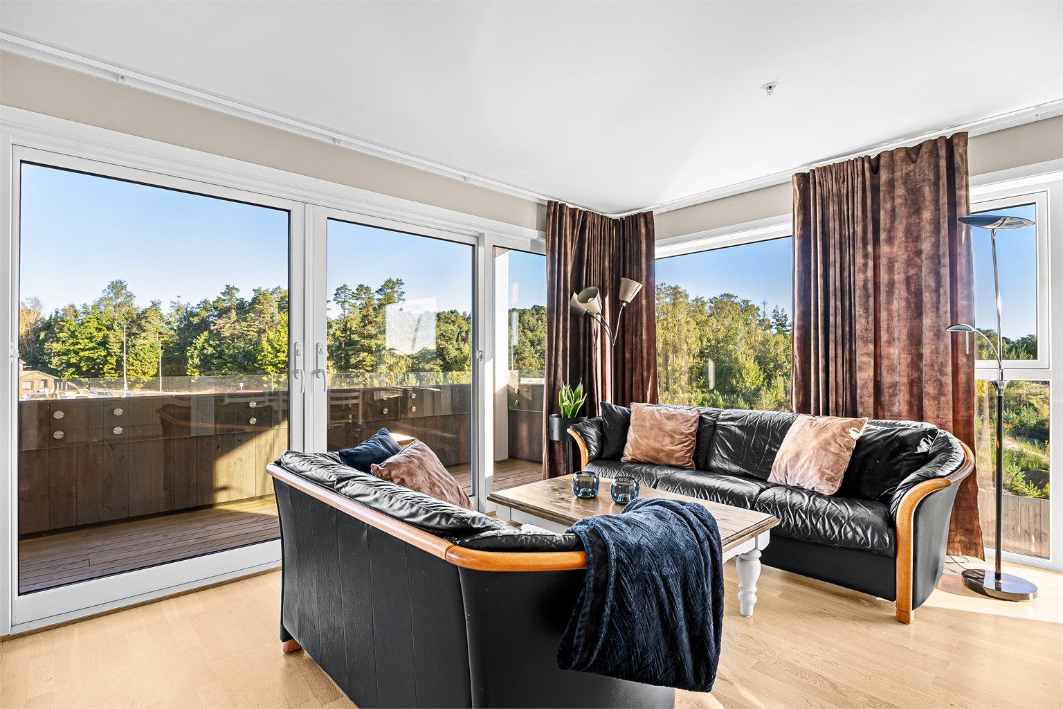 Lys og innbydende stue med store vindusflater og skyvedør til stor uteplass 