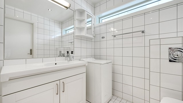 Bad med servant, badekar med dusj, toalett, opplegg til vaskemaskin.