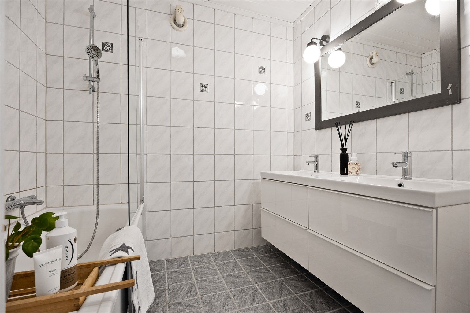 Bad i underetasjen med badekar, dusjløsning og dobbel servant.