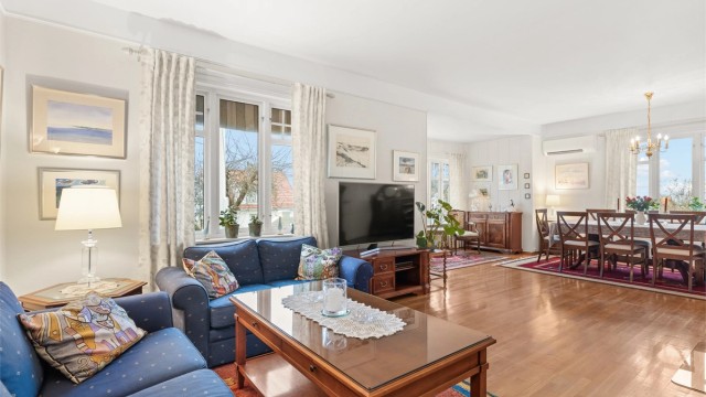 Stuen er lys og romslig, med god plass til både sofagruppe og en stor spisestue.