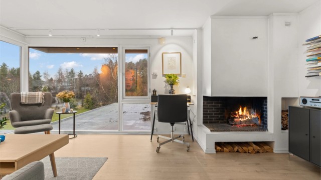 Leiligheten har en åpen og sosial stue med en stemningsfull peis.