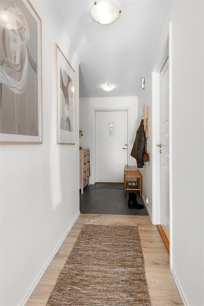 Entrédøren har glassfelt og sikkerhetslås, og gangen binder rommene fint sammen.
