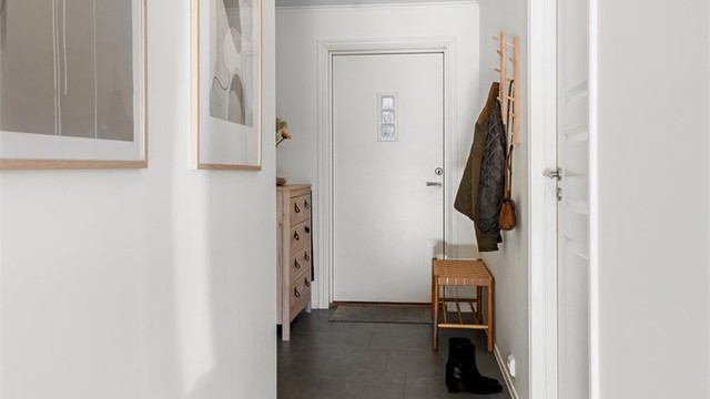 Entrédøren har glassfelt og sikkerhetslås, og gangen binder rommene fint sammen.
