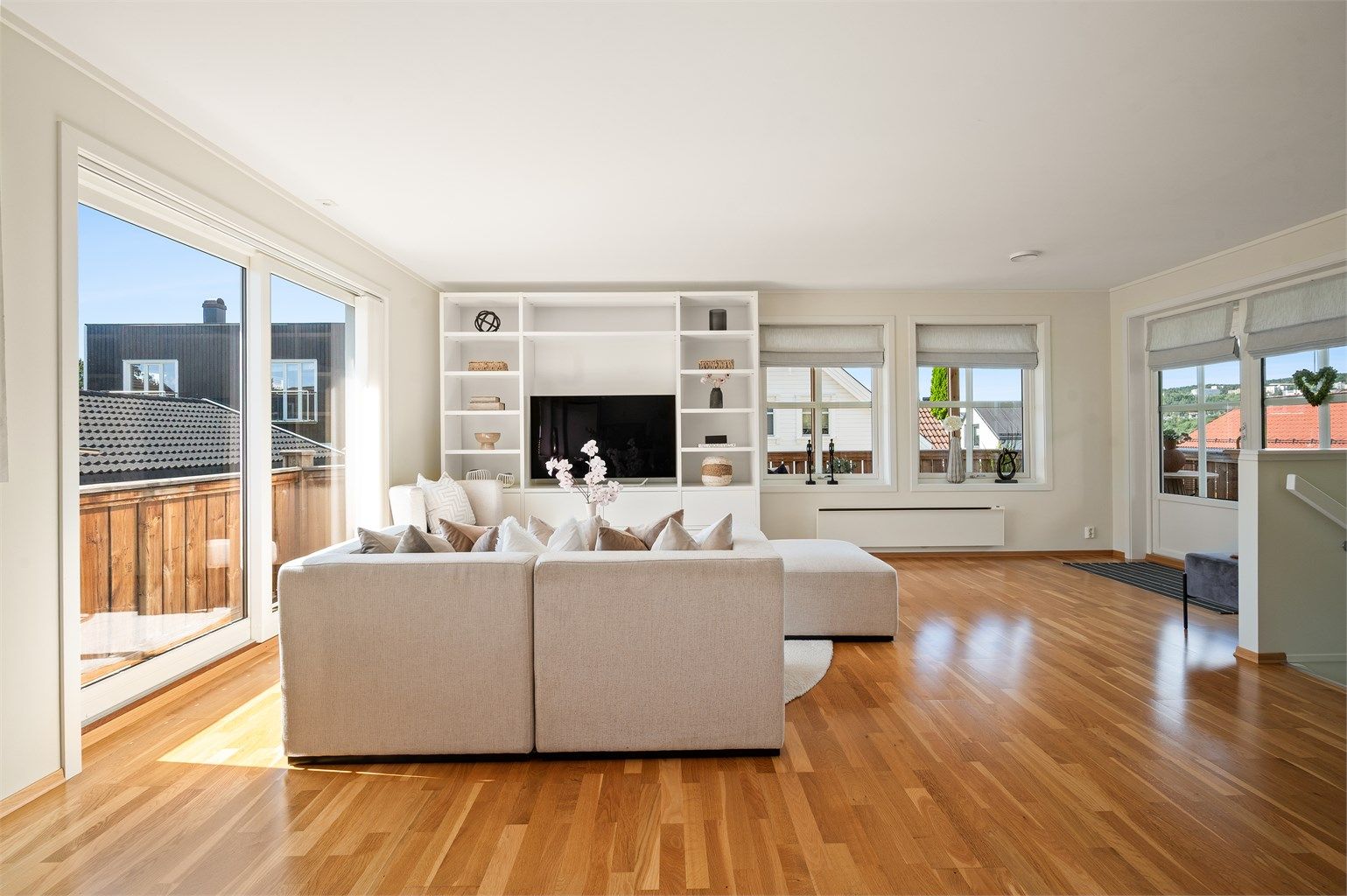 Stuen er lys og moderne med god plass til sofagruppe med tilhørende salongbord og tv-seksjon. Hyllemøblement medfølger boligen