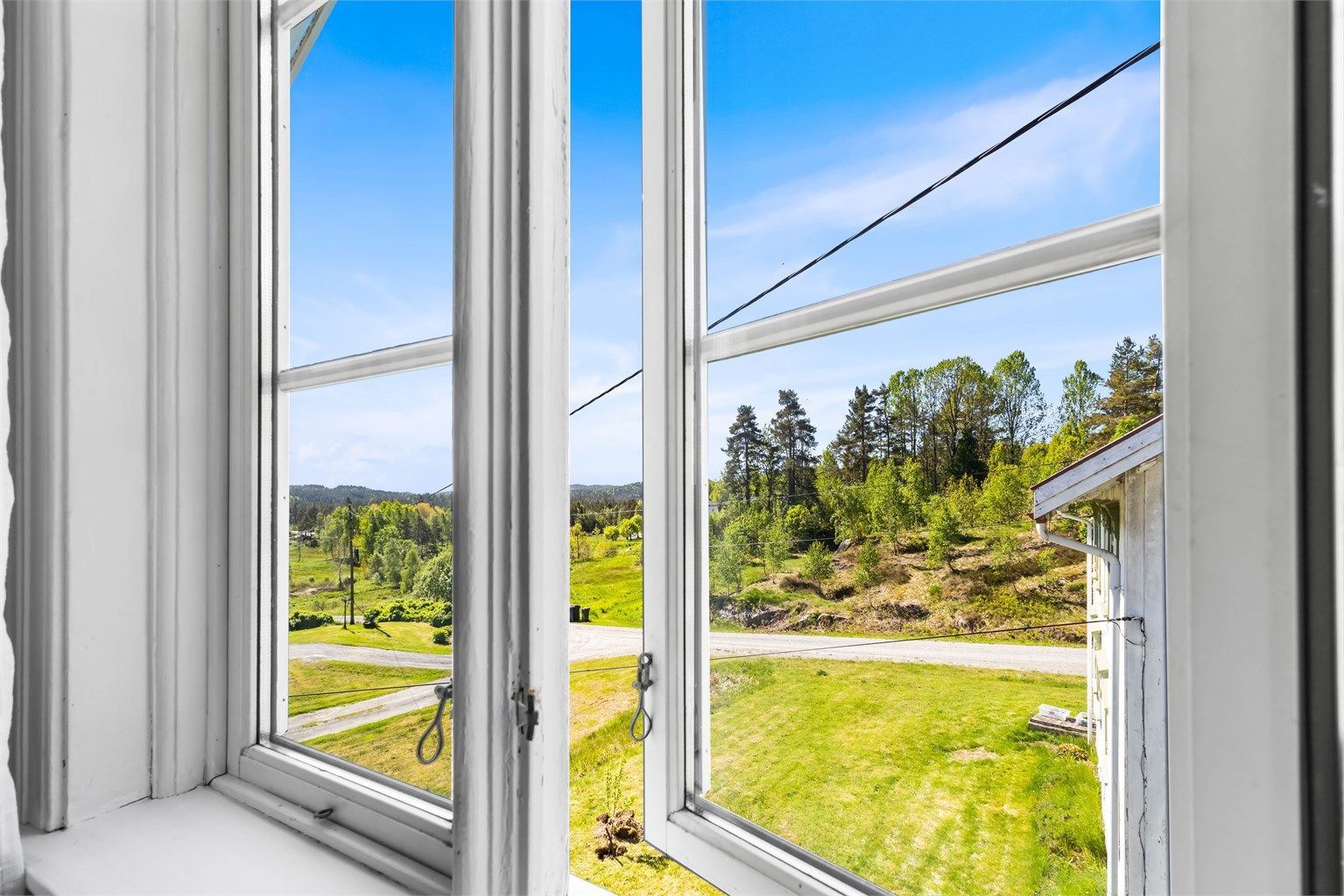Fra vinduene i loftsetasjen har man utsikt over det landlige nærområdet.
