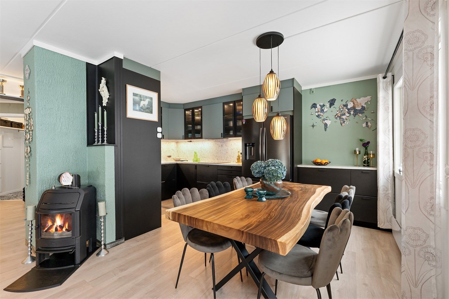  I åpen løsning mot stuen finner du et lekkert kjøkken fra 2022 med glatte fronter på skap og skuffer, og benkeplate av stein med nedfelt kjøkkenvask