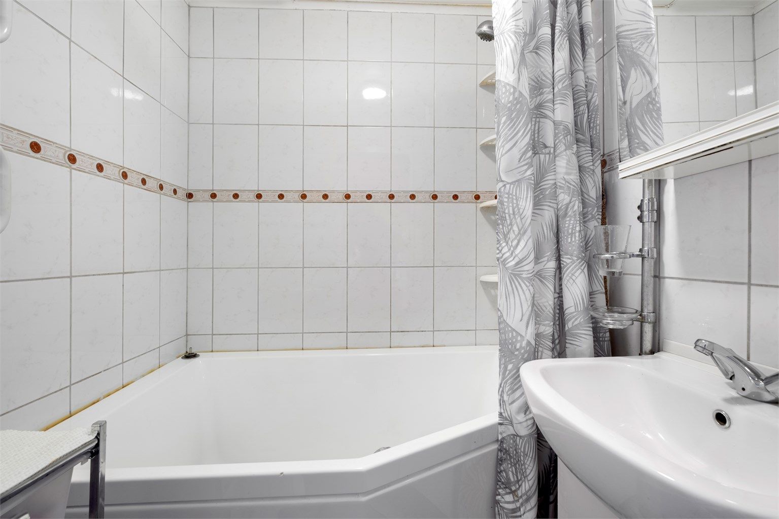 Pent flislagt bad på 2 kvm med servantskap med overskap og badekar.  