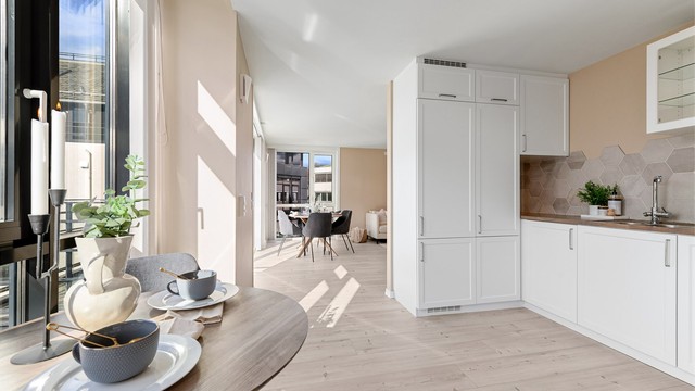 Den åpne løsningen gir god kontakt med stuen. Det er også plass til spisebord på kjøkkenet