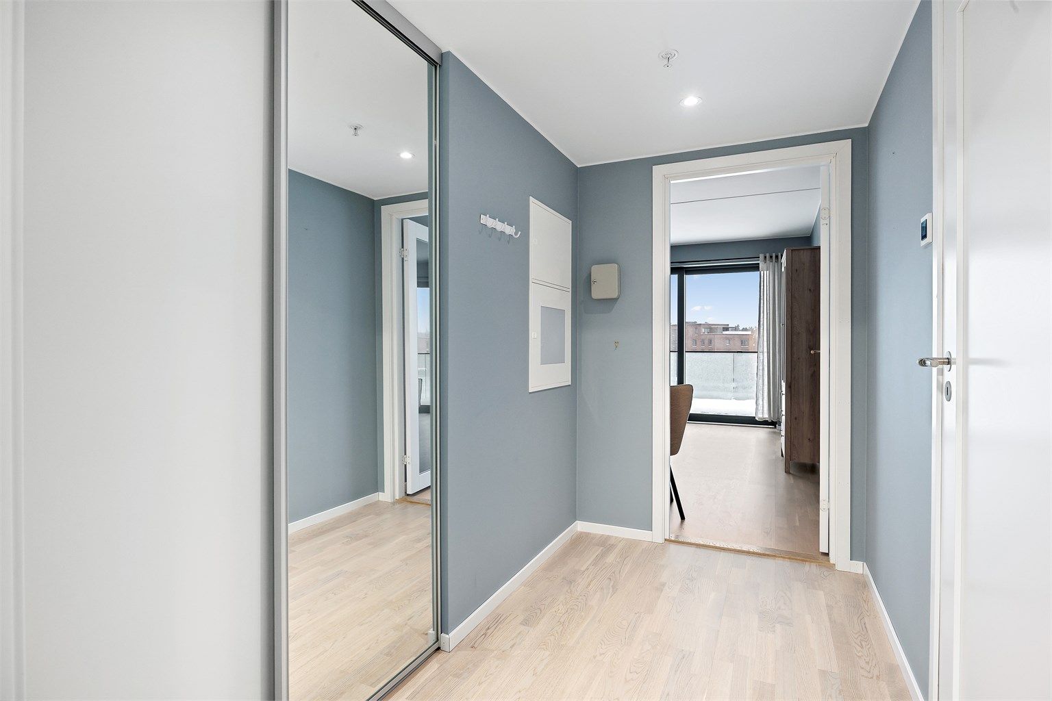 Man kommer inn i en innbydende entré med skyvedørsgarderobe 