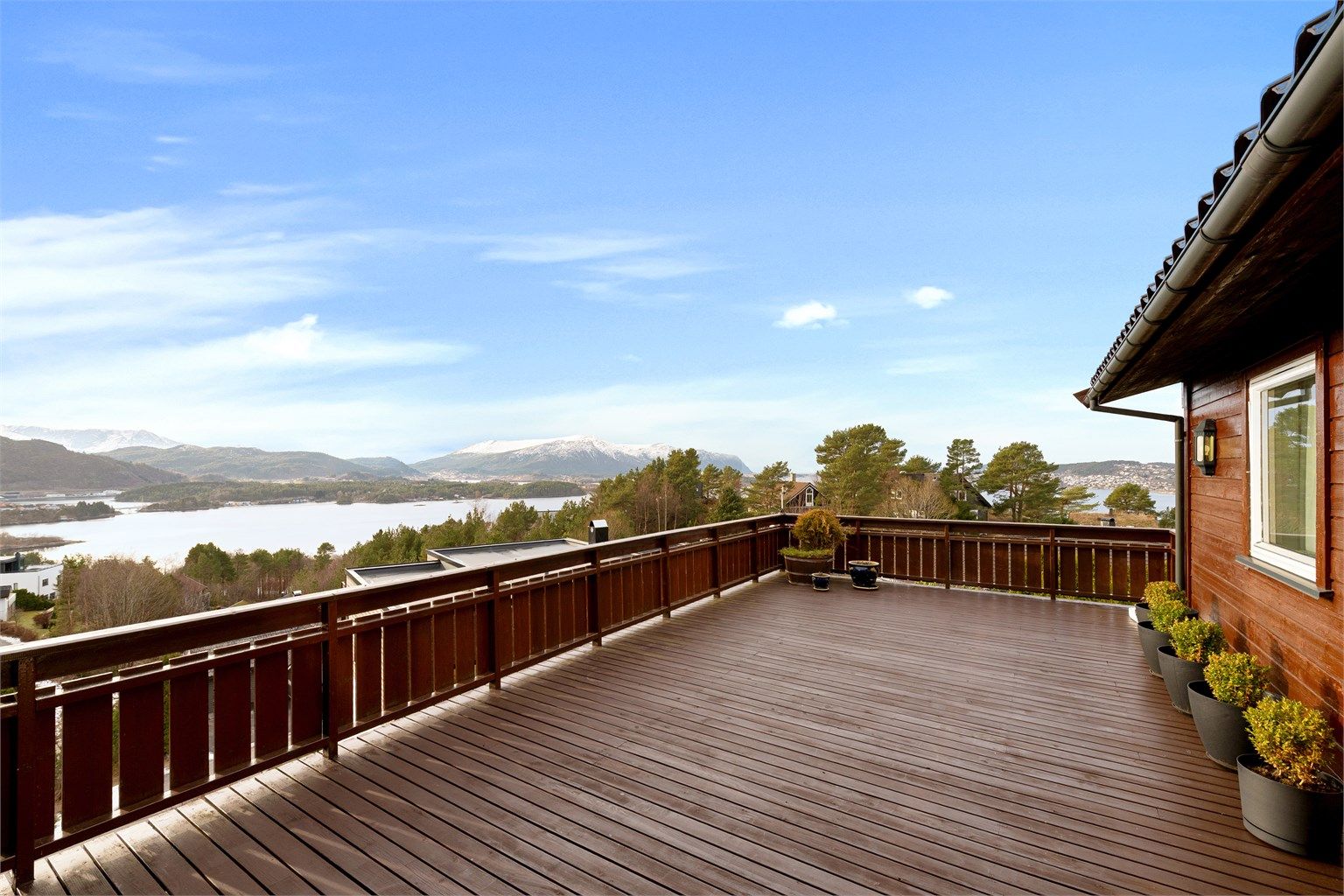 Terrasse på 38 kvm med praktfull utsikt mot fjord og fjell. Utgang fra stue i hovedetasjen samt fra tv-stue/soverom