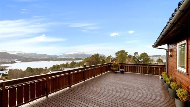 Terrasse på 38 kvm med praktfull utsikt mot fjord og fjell. Utgang fra stue i hovedetasjen samt fra tv-stue/soverom