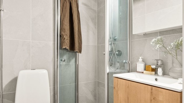 Lekkert flislagt bad fra 2025 med gulvvarme.