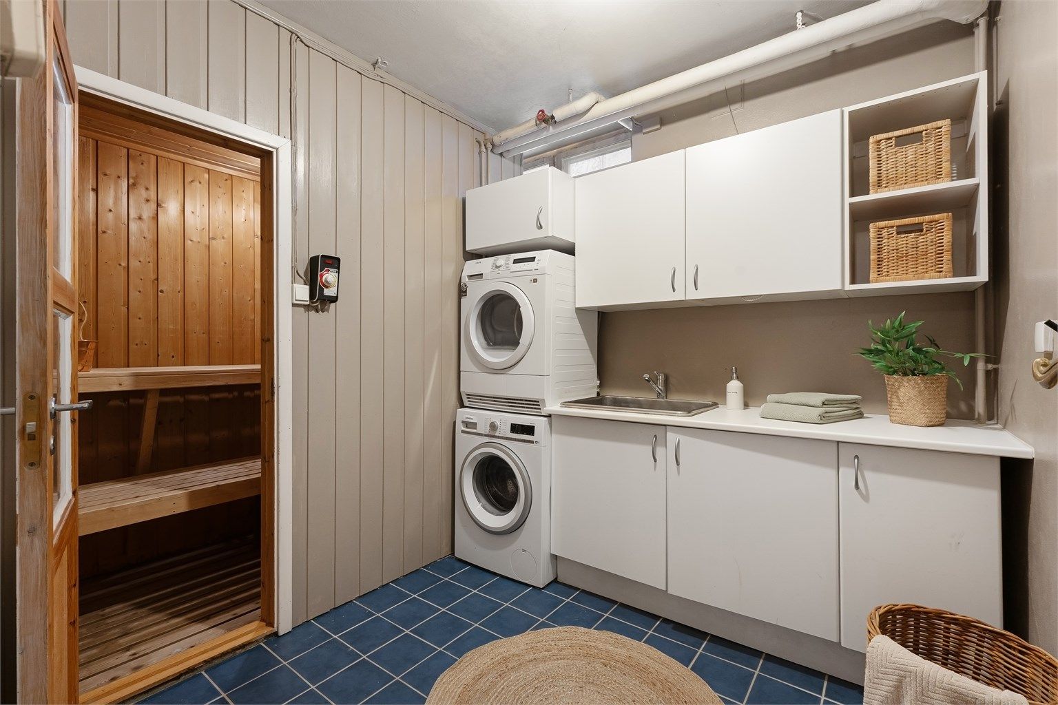 Praktisk vaskerom med flislagt gulv, nedstøpt vannbåren varme og god plass til vaskemaskin.