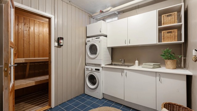 Praktisk vaskerom med flislagt gulv, nedstøpt vannbåren varme og god plass til vaskemaskin.
