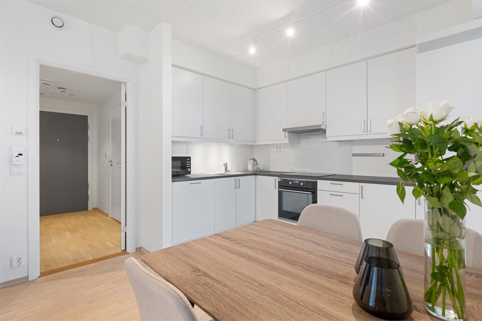 Lyst og funksjonelt kjøkken med åpen løsning mot stuen, som skaper en sosial og romslig atmosfære. 