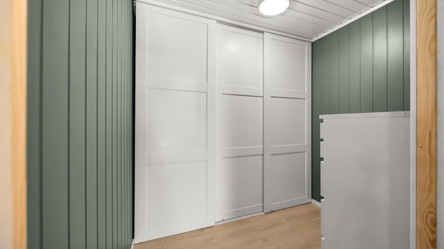 Praktisk garderobe med skyvedører gir rikelig med oppbevaringsplass.