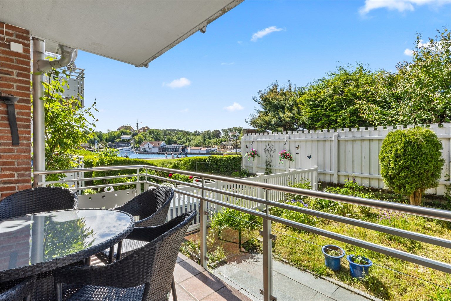 Lunt og sjarmerende uteområde med overbygd veranda og hage med trapp til privat hage