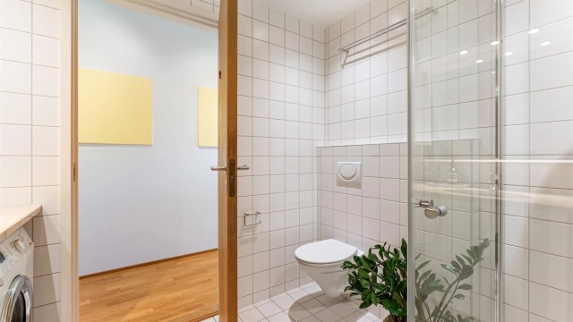 Vegghengt toalett og dusjsone med innfellbare glassvegger.