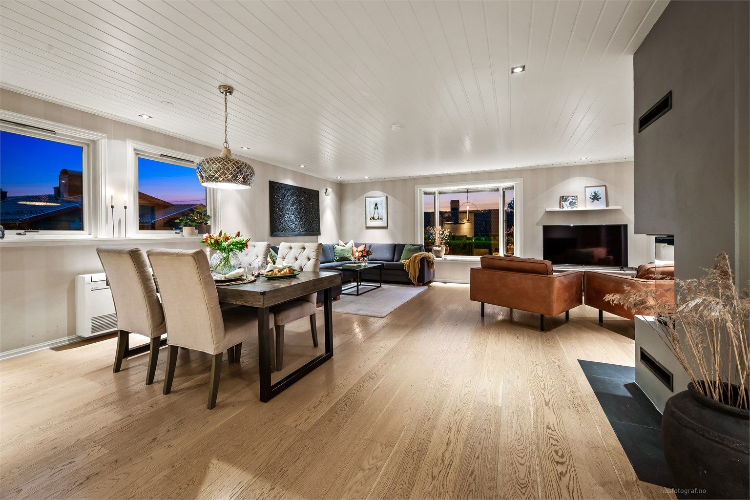 Stuen er lys og luftig med plass til både sofagruppe og spisebord.