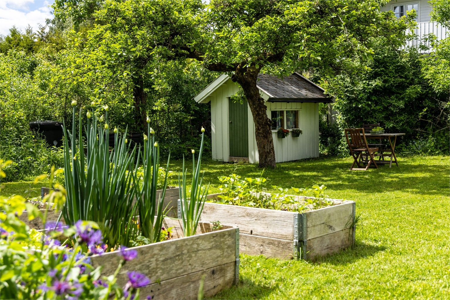 Den store hagen er opparbeidet med diverse flott beplantning og en dukkestue.