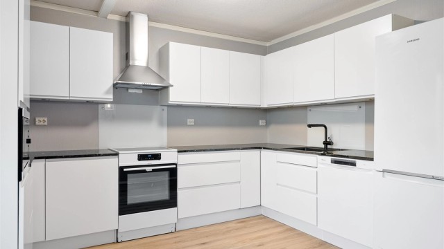 Kjøkkenet er fra Aubo (2019) har et tidløst design med glatte fronter og en solid benkeplate i stein