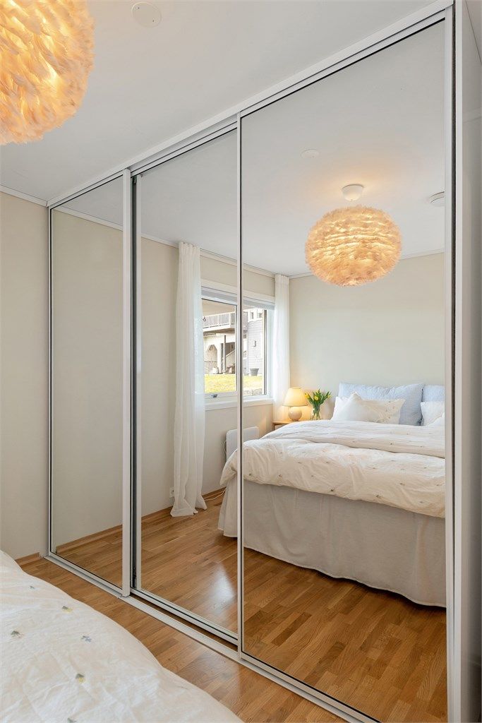 En romslig skyvedørsgarderobe med speilfronter gir rikelig med oppbevaringsplass.