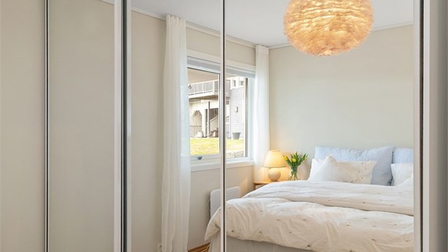En romslig skyvedørsgarderobe med speilfronter gir rikelig med oppbevaringsplass.