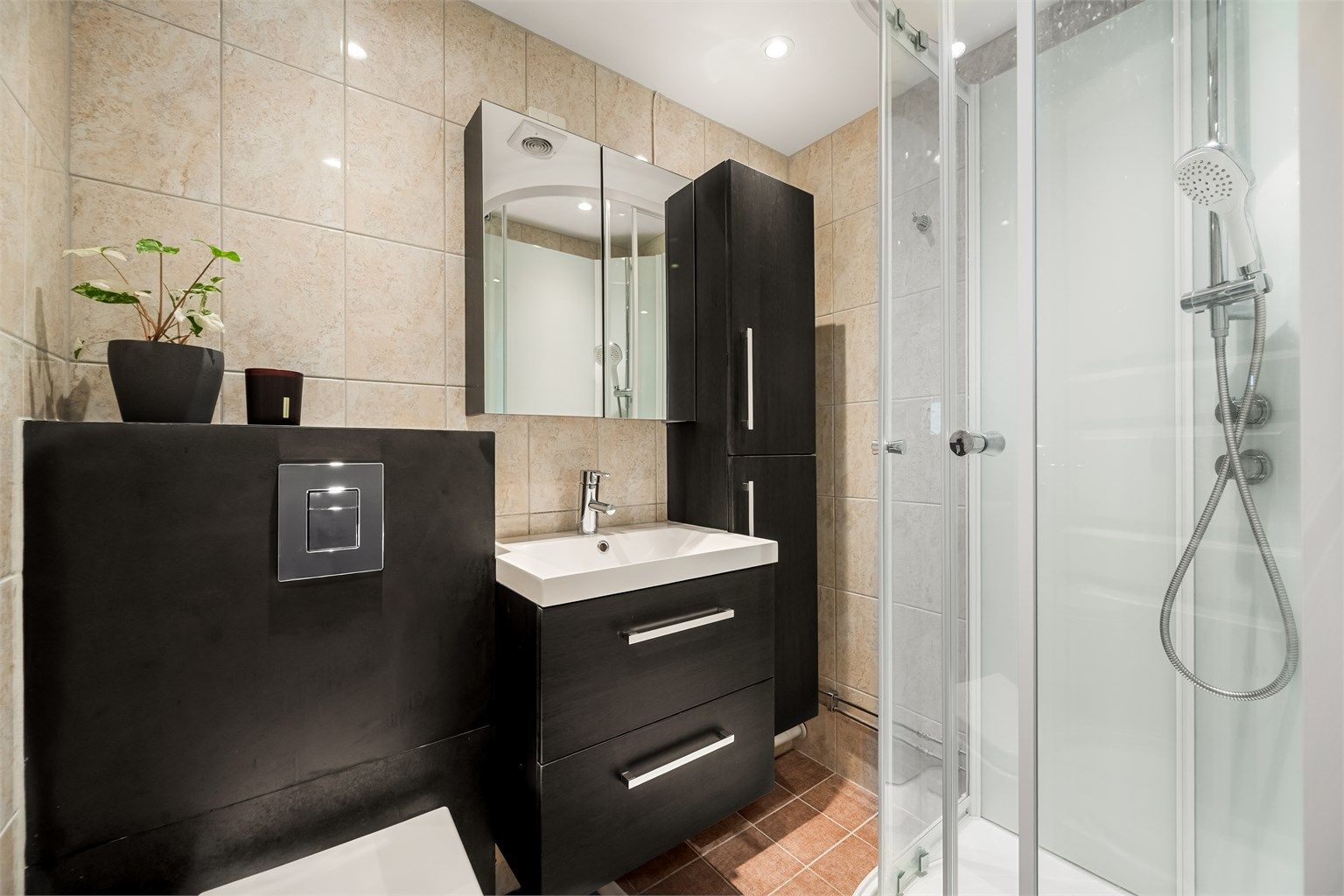 Her finner du et praktisk dusjkabinett og mekanisk avtrekk i himlingen.