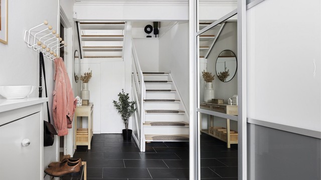 Entréen har flislagt gulv med varmekabler og stor skyvedørsgarderobe.