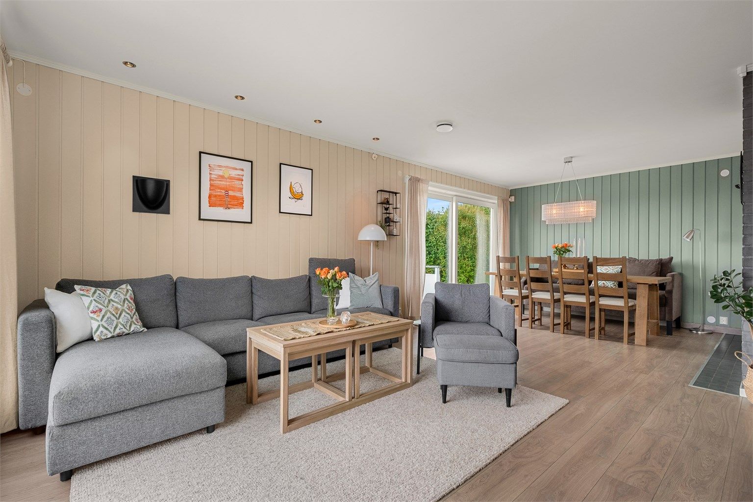 En åpen og sosial planløsning knytter stuen sammen med spisestuen, samtidig som rommet har god plass til sofagruppe.