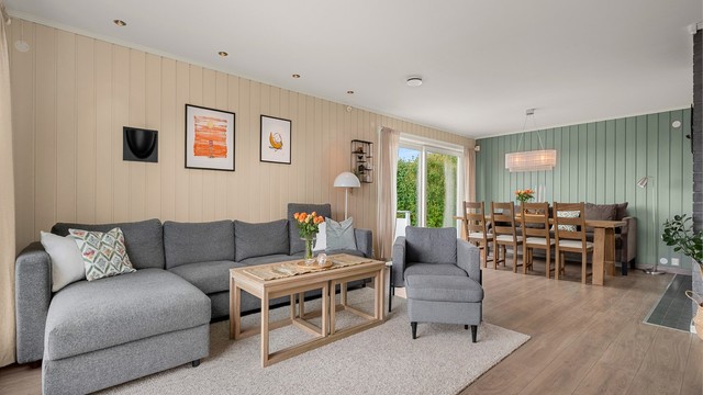 En åpen og sosial planløsning knytter stuen sammen med spisestuen, samtidig som rommet har god plass til sofagruppe.