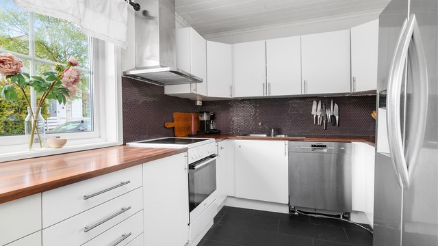 Kjøkkeninnredning med glatte fronter og laminat benkeplate. Alle hvitevarer medfølger.