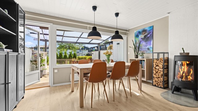 Endeveggen har store vinduer som gir mye lysinslipp, og glassdør ut til en solrik terrasse.