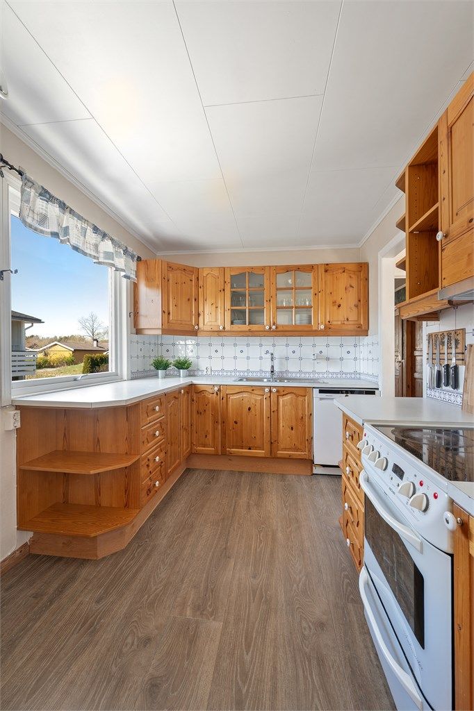 Kjøkkenet har en praktisk innredning med god skap og benkeplass.